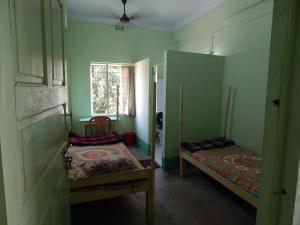 a small room with two beds and a window at Seva Kendra Hijli Kharagpur in Kharagpur