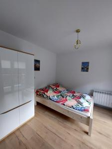 1 dormitorio con 1 cama y armario blanco en Pokój studio z balkonem, en Grywałd