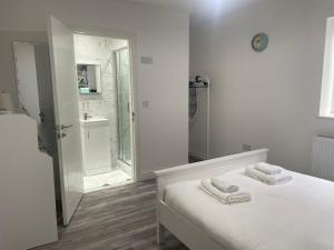 a white bathroom with a bed with two towels on it at CityBreaks Rooms with Free Parking in Liverpool