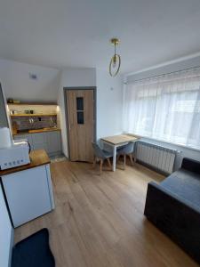a living room with a table and a dining room at Pokój studio z balkonem in Grywałd +3 photos