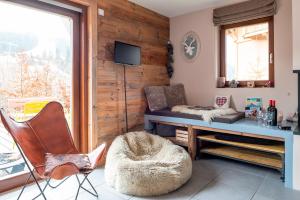 un salon avec un canapé, une table et des chaises dans l'établissement Apartment Marmottes Suisses, aux Gets