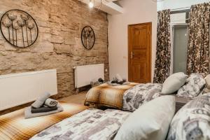 a bedroom with two beds and a stone wall at Narva Castle Rooms in Narva
