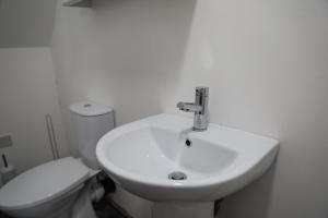 a white bathroom with a sink and a toilet at Cosy Loft situated on shores of Lough Neagh 