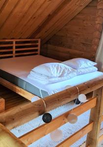 a bed in the attic of a wooden cabin at NPLIHOUSE in Otepää