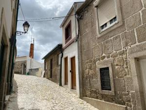 eine leere Gasse mit einem Steingebäude und einer Straße in der Unterkunft Casa Portas 8&10 in Lamego