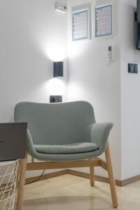 einen grünen Stuhl in einem Zimmer mit einer Lampe in der Unterkunft Travel Habitat La Marina Real in Valencia