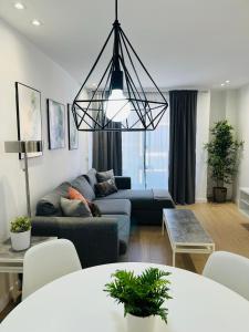 een woonkamer met een bank en een kroonluchter bij Premium La Strada in Las Palmas de Gran Canaria