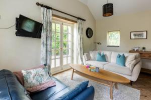 a living room with a couch and a table at The Cow Shed Luxury Barn Moments From Narberth in Pembrokeshire