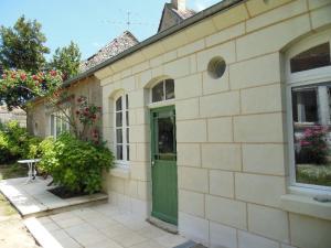 ein Backsteingebäude mit einer grünen Tür und einem Fenster in der Unterkunft Appartements Yzeures Sur Creuse in Yzeures-sur-Creuse