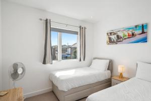 a bedroom with two beds and a window at 5 The Dunes in Perranporth