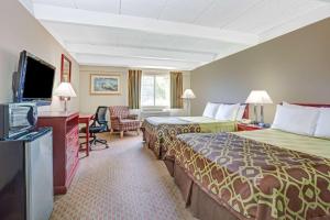 a hotel room with two beds and a flat screen tv at Travelodge by Wyndham Iowa City in Iowa City