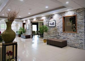 un vestíbulo con una pared de ladrillo y un jarrón en Days Inn & Suites by Wyndham Savannah North I-95, en Port Wentworth
