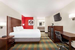 a hotel room with a bed and a desk and a computer at Ramada by Wyndham San Antonio Near SeaWorld - Lackland AFB in San Antonio