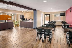 a lobby with a restaurant with tables and chairs at Ramada by Wyndham San Antonio Near SeaWorld - Lackland AFB in San Antonio