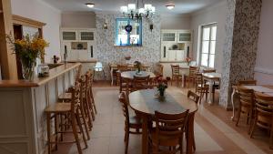 uma sala de jantar com mesas e cadeiras e uma cozinha em Biały Dom Kazimierski em Kazimierz Dolny