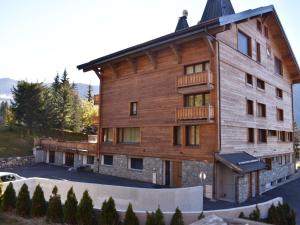 un gran edificio de madera con balcón en Appartement Méribel, 2 pièces, 6 personnes - FR-1-180-95, en Méribel