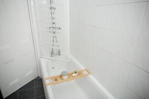 a bathroom with a bath tub with a shower stall at Bonhill Getaway in Dumbarton