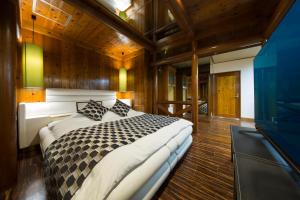 a bedroom with a large bed in a room with wooden walls at ホテル　ミロワール in Hirakata