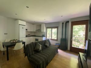 een woonkamer met een bank en een tafel bij Precioso apartamento con vistas montaña y rio in Ribes de Freser