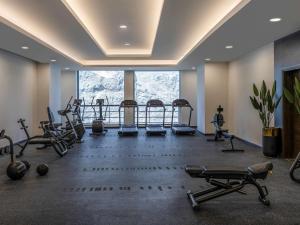 a gym with cardio equipment and a large window at Novotel Makkah Thakher City in Makkah