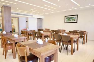 a dining room with wooden tables and chairs at Luciana Hotel in Aqaba