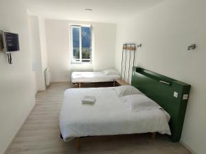 Un dormitorio con una cama grande y una ventana en le payanké ardéchois, en Saint-Martin-de-Valamas