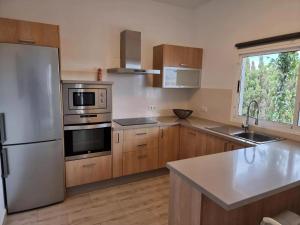 Casa Abubilla في Nazaret: مطبخ مع أجهزة ستانلس ستيل ودواليب خشبية