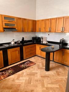 una cocina con armarios de madera y una mesa. en Villa DAAD OURIDA piscine chauffée, en Marrakech