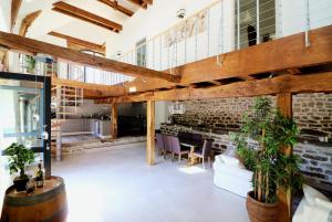 uma sala de estar em plano aberto com uma parede de tijolos e tectos em madeira em Maison de 3 chambres avec jardin amenage et wifi a Thegra em Thégra