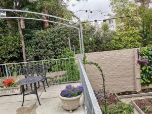 patio ze stołem, krzesłem i kwiatami w obiekcie Cape Dawn Guest House w mieście Parow