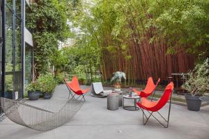 魯貝的住宿－LA PORTE ROUGE RBX，庭院配有红色的椅子和桌子