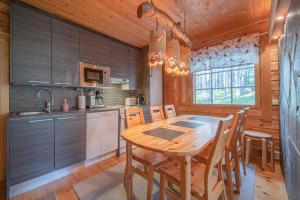 a kitchen with a wooden table and chairs in a room at Levillas Lomakoto 1 in Levi