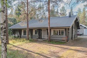 a house with a gray roof and trees at Levillas Lomakoto 1 in Levi