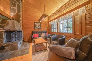 a living room with a fireplace in a log cabin at Levillas Lomakoto 1 in Levi