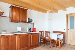 a kitchen with wooden cabinets and a table and chairs at Hotel & Restaurant Pahor in Doberdò del Lago