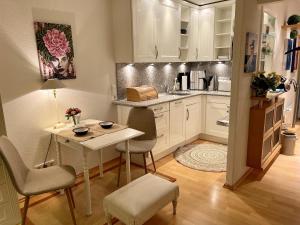 uma cozinha com uma mesa e cadeiras e uma mesa e uma mesa em Apartment am Meer em Sierksdorf
