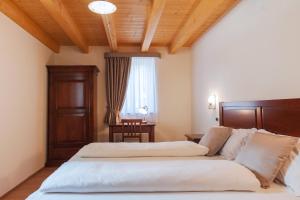 a bedroom with two beds and a table and a window at Hotel & Restaurant Pahor in Doberdò del Lago