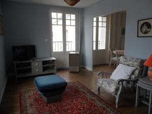 ein Wohnzimmer mit einem Stuhl und einem TV in der Unterkunft Appartements Yzeures Sur Creuse in Yzeures-sur-Creuse