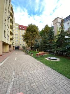 a courtyard with benches and a park with buildings at Murano Apartaments Nova Praga in Warsaw