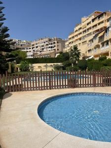 a swimming pool in front of a building at Sea and mountain view Room with pool- Habitación PISO COMPARTIDO para 1 persona in Benalmádena