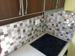 a kitchen with a sink in a tiled counter top at Jasmina Apartments in Ksamil