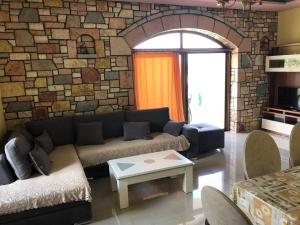 sala de estar con sofá y pared de ladrillo en Jasmina Apartments, en Ksamil