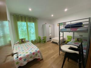 a bedroom with a bunk bed and a bedroom with a desk at Precioso apartamento con vistas montaña y rio in Ribes de Freser