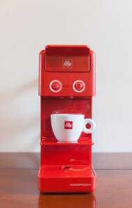 a red espresso machine with a cup on top at Hotel & Restaurant Pahor in Doberdò del Lago