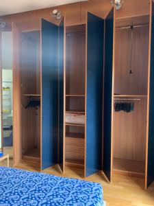 - une chambre avec des murs bleus et des placards en bois dans l'établissement Casa di Vanessa, à Bologne