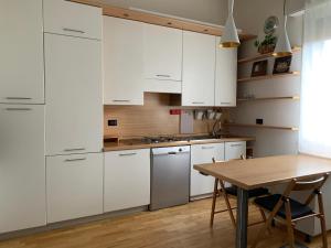 eine Küche mit weißen Schränken und einem Holztisch in der Unterkunft Casa di Vanessa in Bologna
