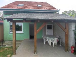 einen Pavillon mit einem Tisch und Stühlen auf einer Terrasse in der Unterkunft Green Gables in Zalakaros