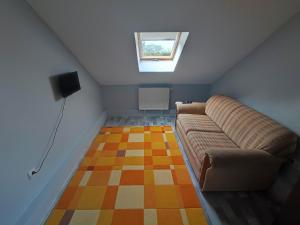 a living room with a couch and a window at Green Gables in Zalakaros