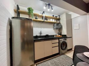 a kitchen with a stainless steel refrigerator and a dishwasher at Loft Studio 308 no Kobrasol à 7km de Floripa in São José