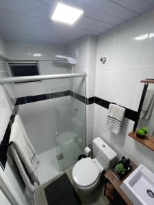 ein Bad mit einer Dusche, einem WC und einem Waschbecken in der Unterkunft Studio 308 no Kobrasol à 7km de Floripa in São José